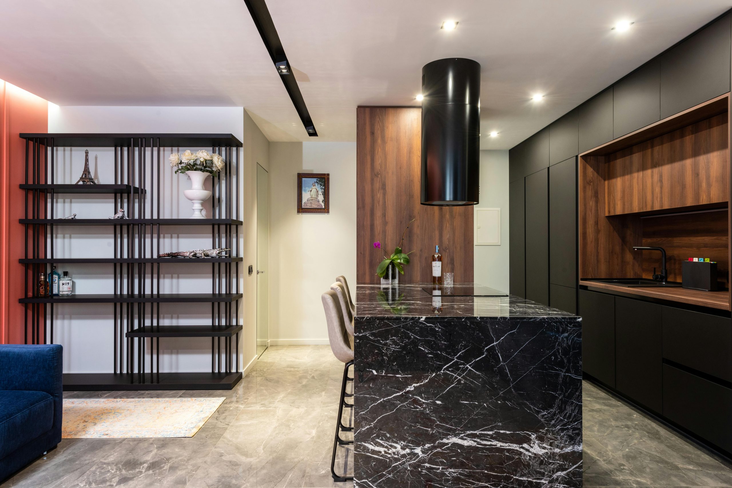 Home Modern kitchen interior with black marble island and wooden cabinets, featuring a sleek design.